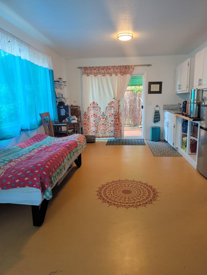 The Healing Room: a bright, open room with a rest bed, soft curtains, and a painted mandala on the floor